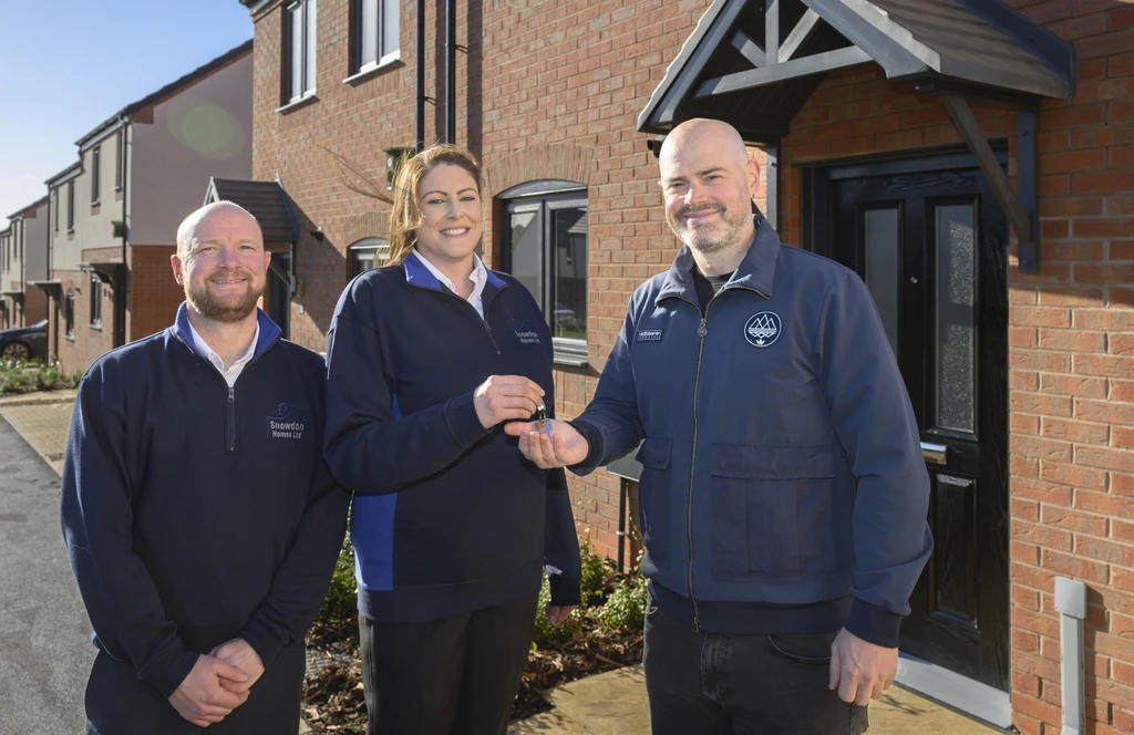 Three people outside new build home