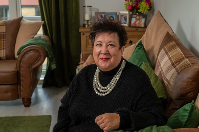Jackie sat on her sofa in her living room