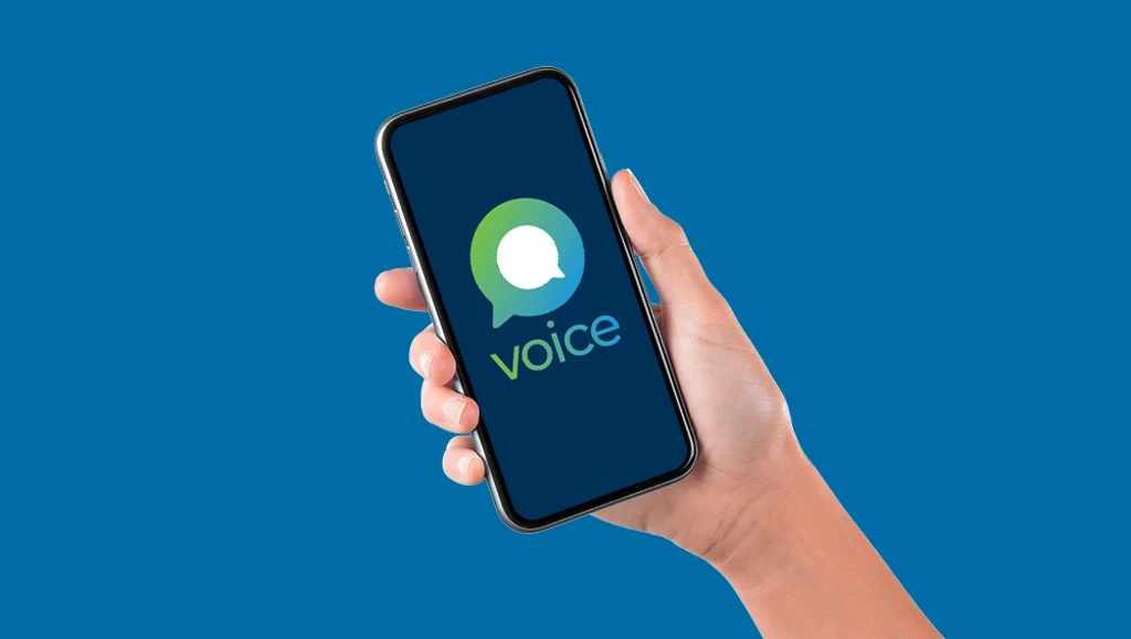 Person holding a mobile phone displaying the Voice logo on screen