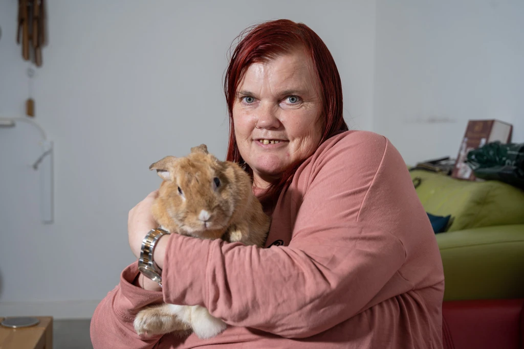 Supported customer Julie, cuddling her pet rabbit