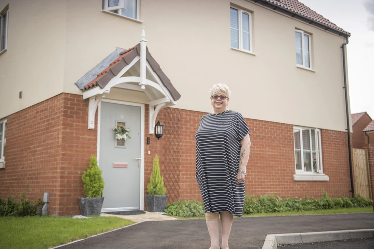 Dana standing outside her house