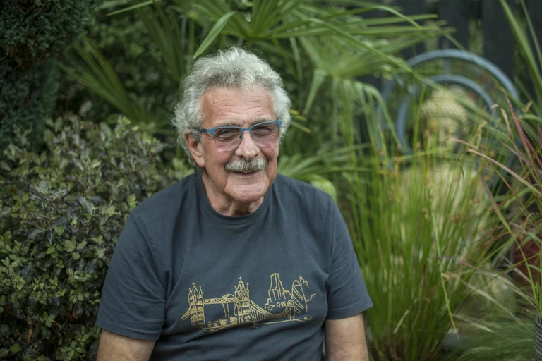 Peter sitting in front of the pond in his garden