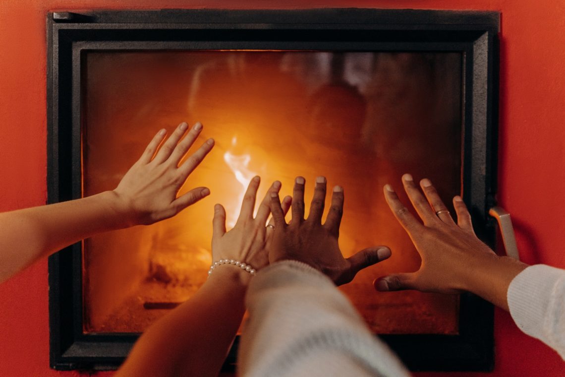 Two people warming their hands in front of a fire