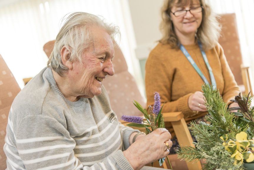 Elderly lady arranging flowers at an activity day