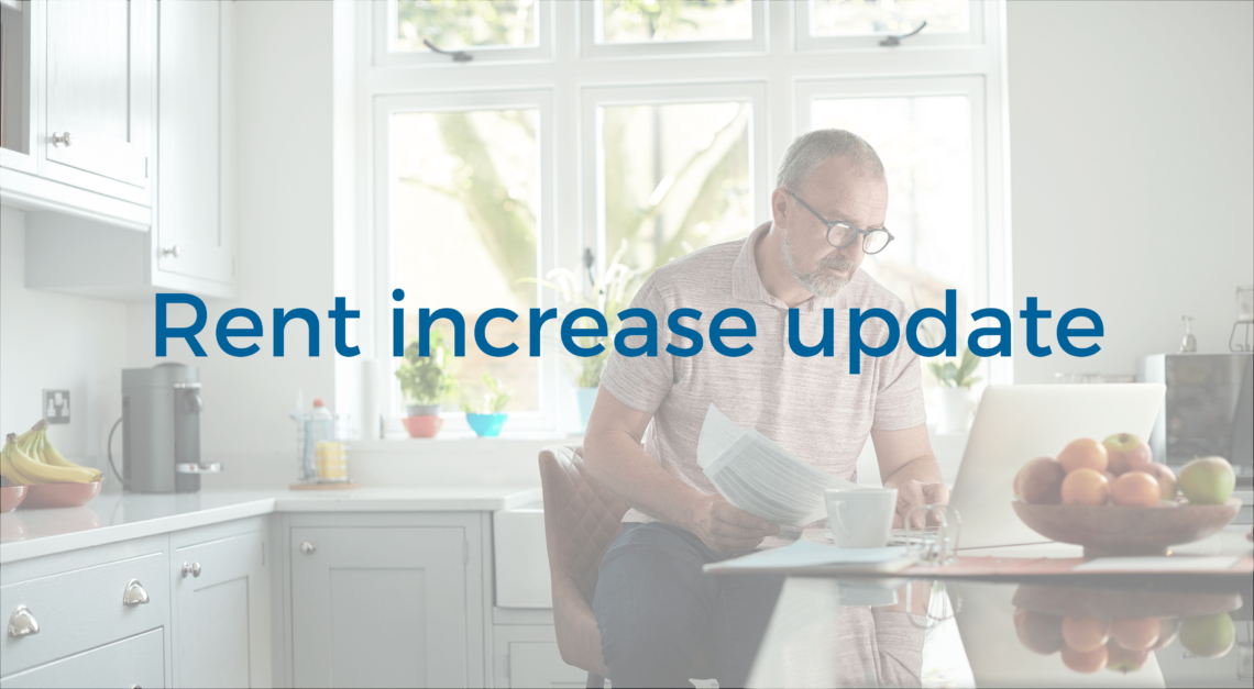 Rent increase update title text. Image of man sitting in kitchen.