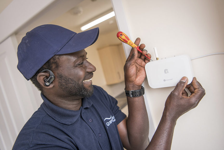 Grand Union operative installing an environmental sensor in a customer's home