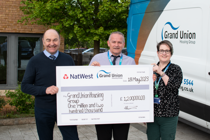 Image of Doug Grace, James Devlin and Emma Hornett holding giant cheque for £1.2million.
