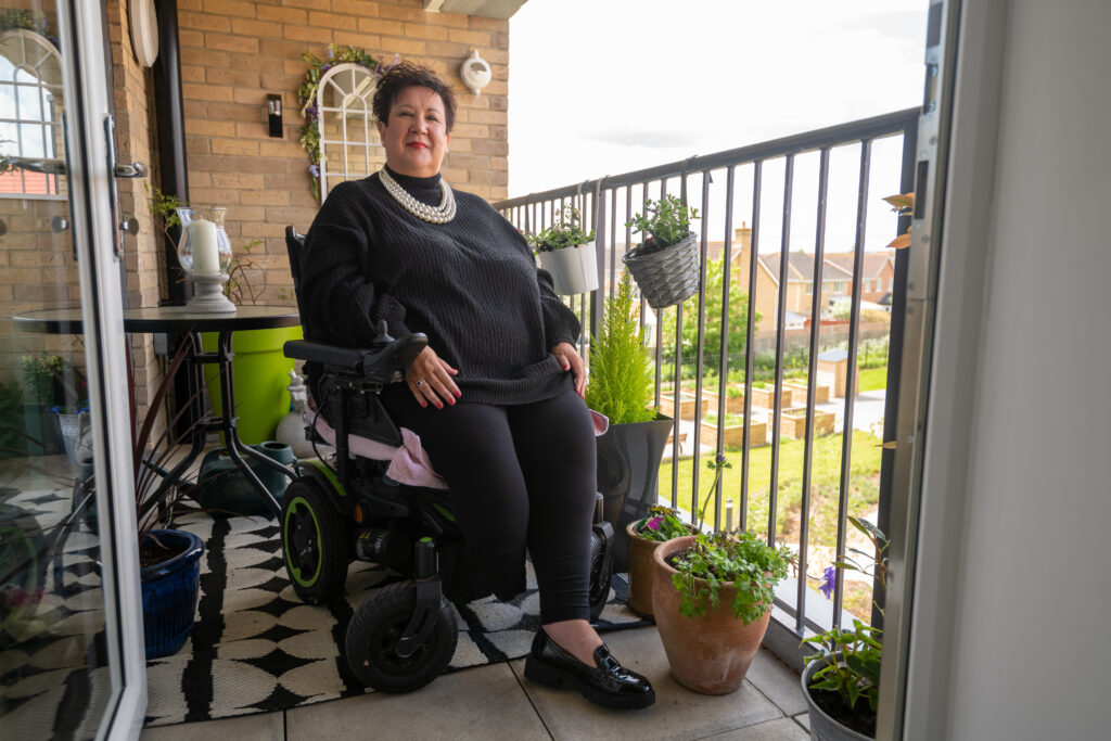 Jackie in her wheelchair, sitting on her balcony