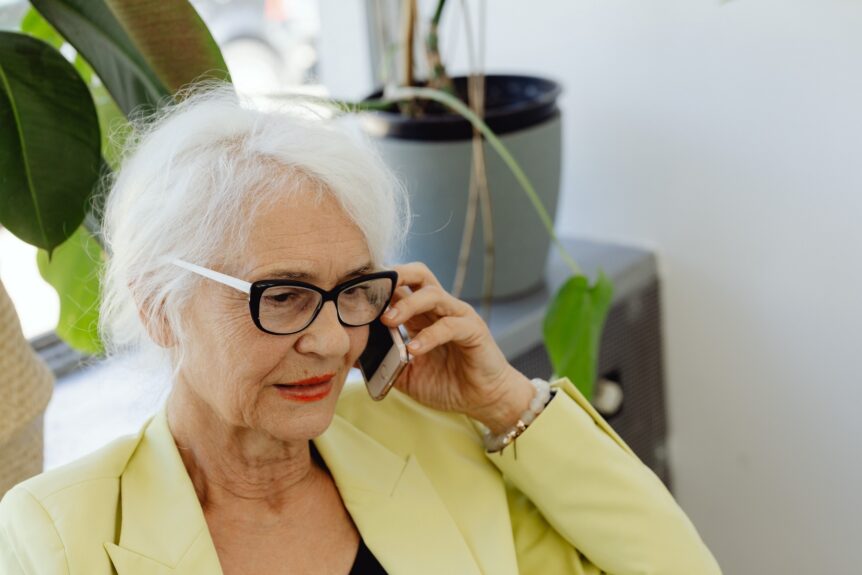 Elderly woman wearing glasses using a mobile phone