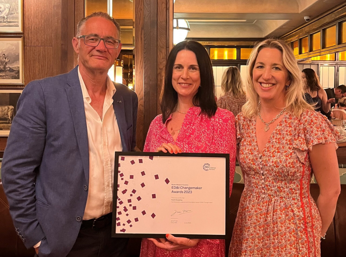 Naomi Sweeting, Director of Customer Experience, holds her special commendation award as she stands between two members of the Market Research Society.