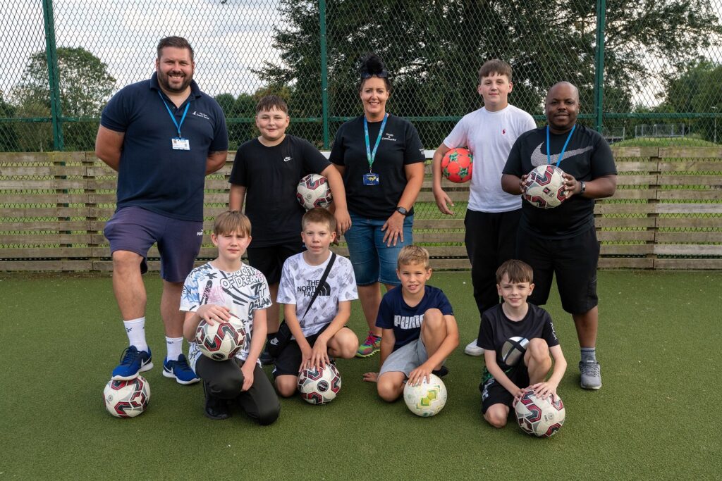 Nicola and other mentors with a group of young people holding footballs