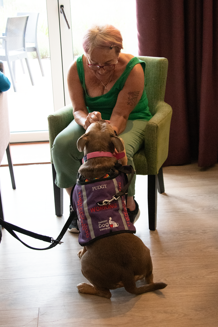 Mary, one of our Chamomile Gardens customers, making a fuss of Pudgy the therapy dog